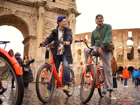 Small group on a guided Rome bike tour passing the Colosseum